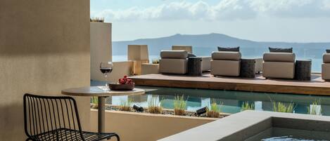 Zona junto a la piscina con sillones, una mesa y una silla.