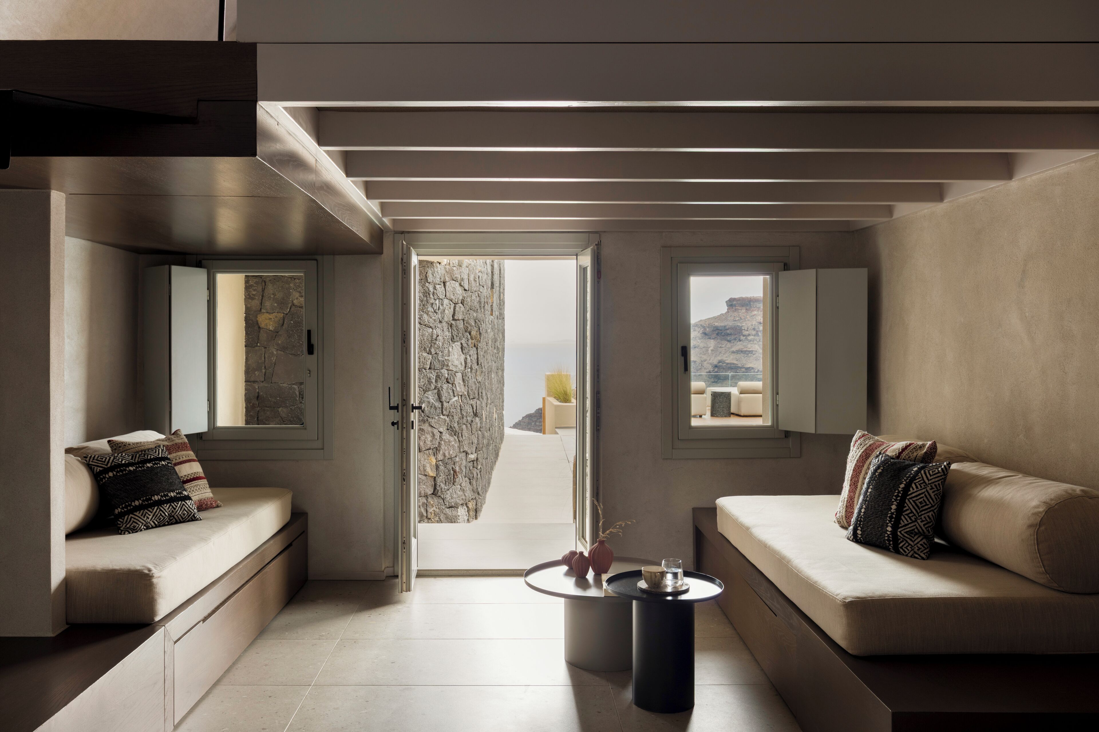 A modern interior with a sofa, a coffee table, and a view through a doorway.