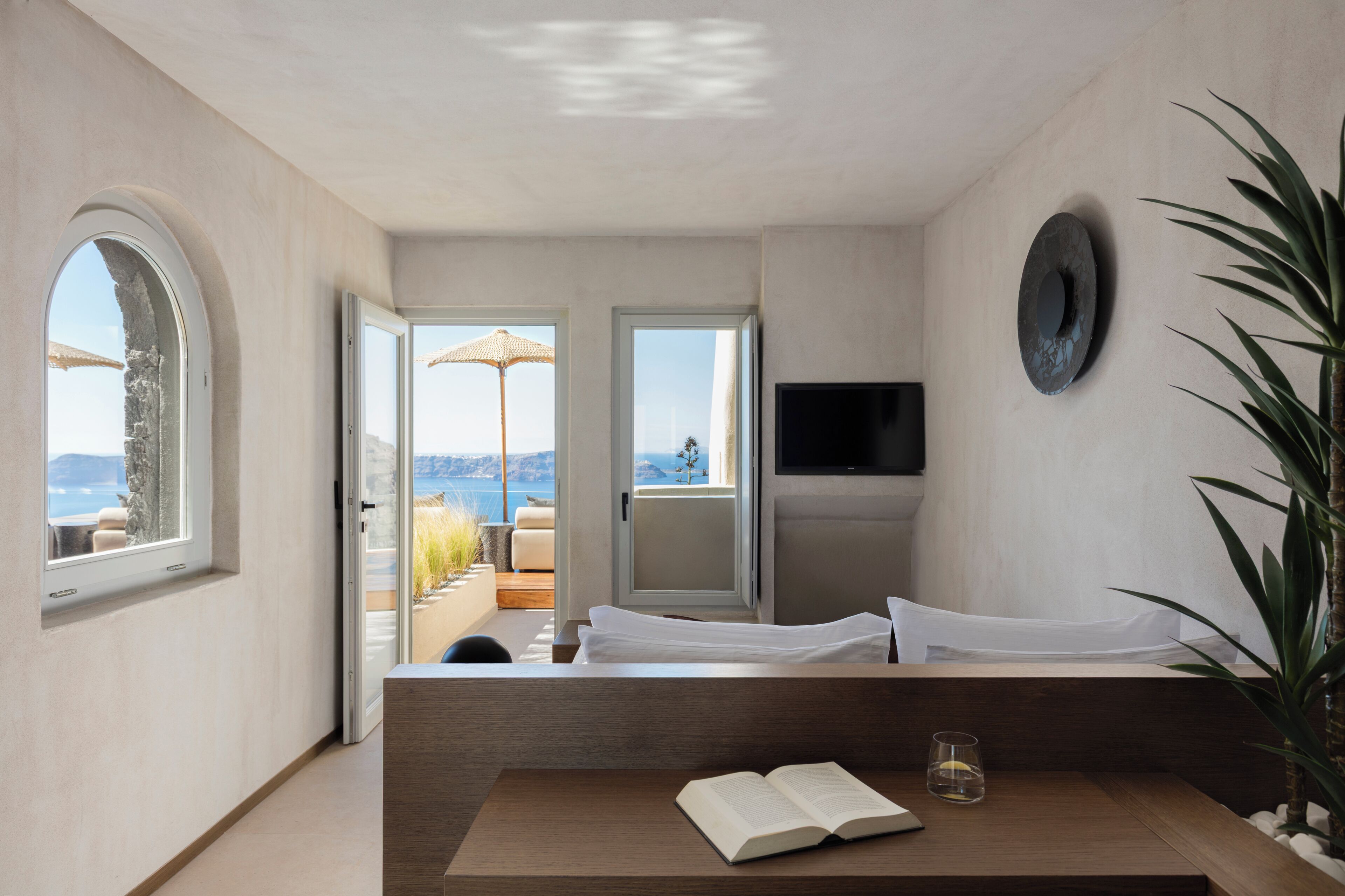 Une chambre moderne avec un lit, une télévision et une vue sur la mer.