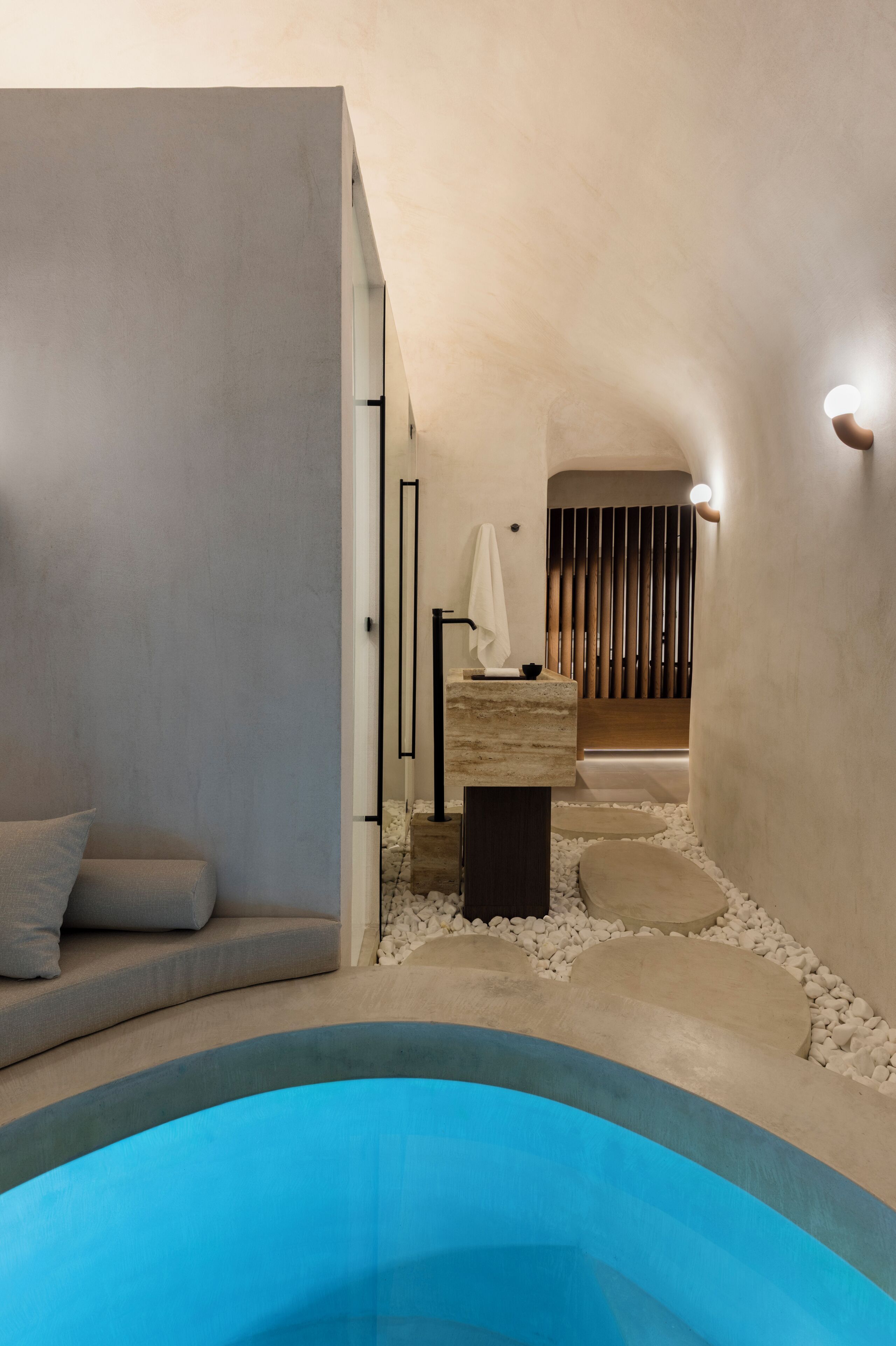 Un baño moderno con bañera integrada, una zona de estar y un perchero.
