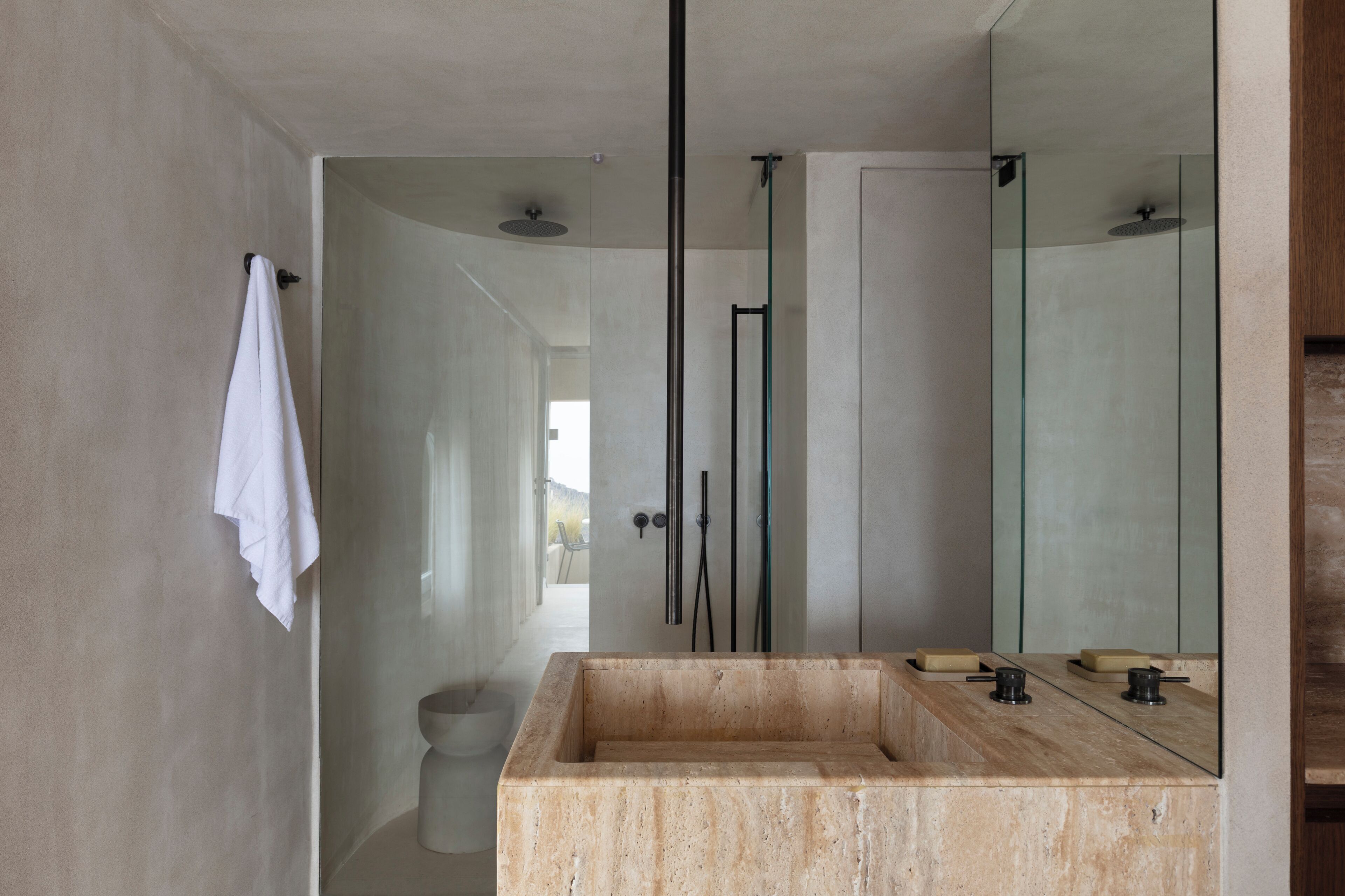 A modern bathroom with a large mirror, a rectangular sink, and a glass-enclosed shower.