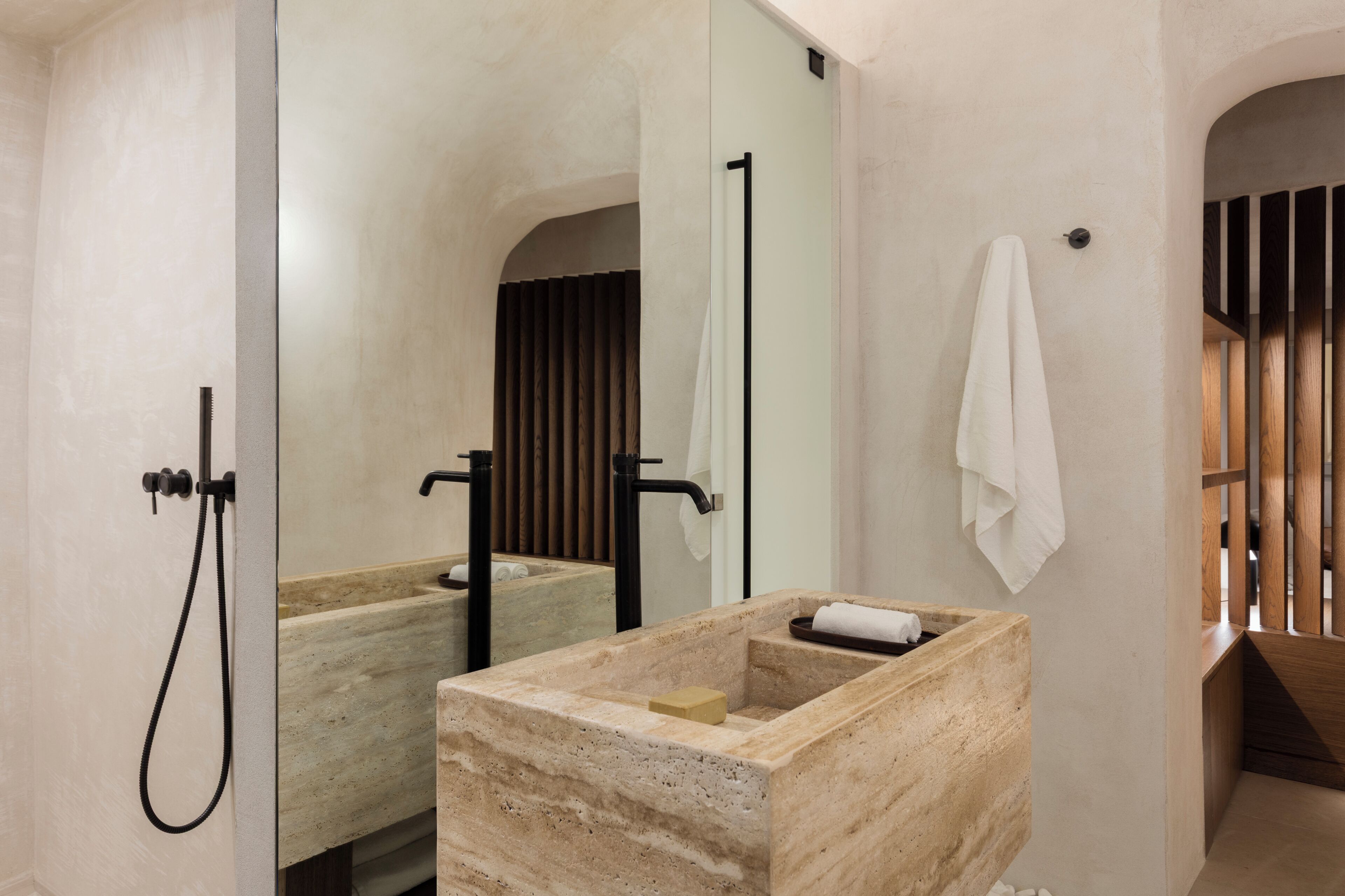 Une salle de bain moderne avec un grand miroir, un meuble-lavabo en bois, une baignoire sur pieds et une serviette accrochée au mur.
