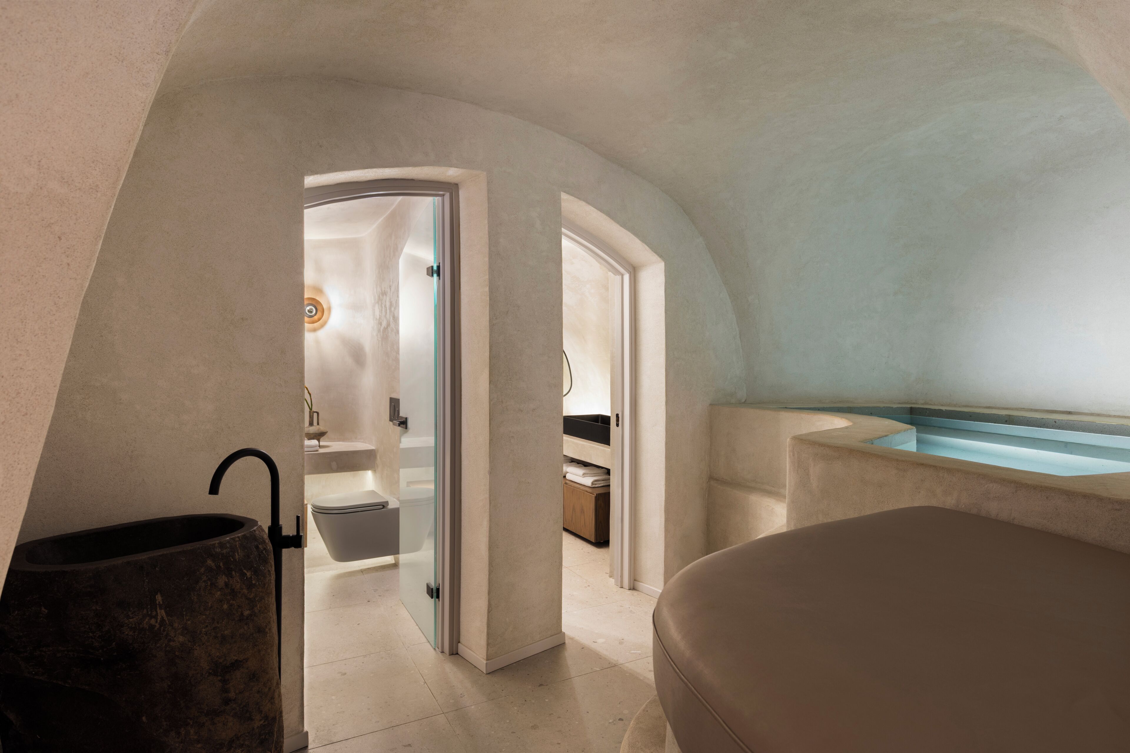 A modern bathroom with a bathtub, a toilet, and a sink.