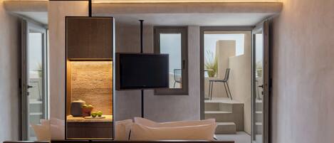 A modern living room with a flat-screen TV, a sofa, and a coffee table.
