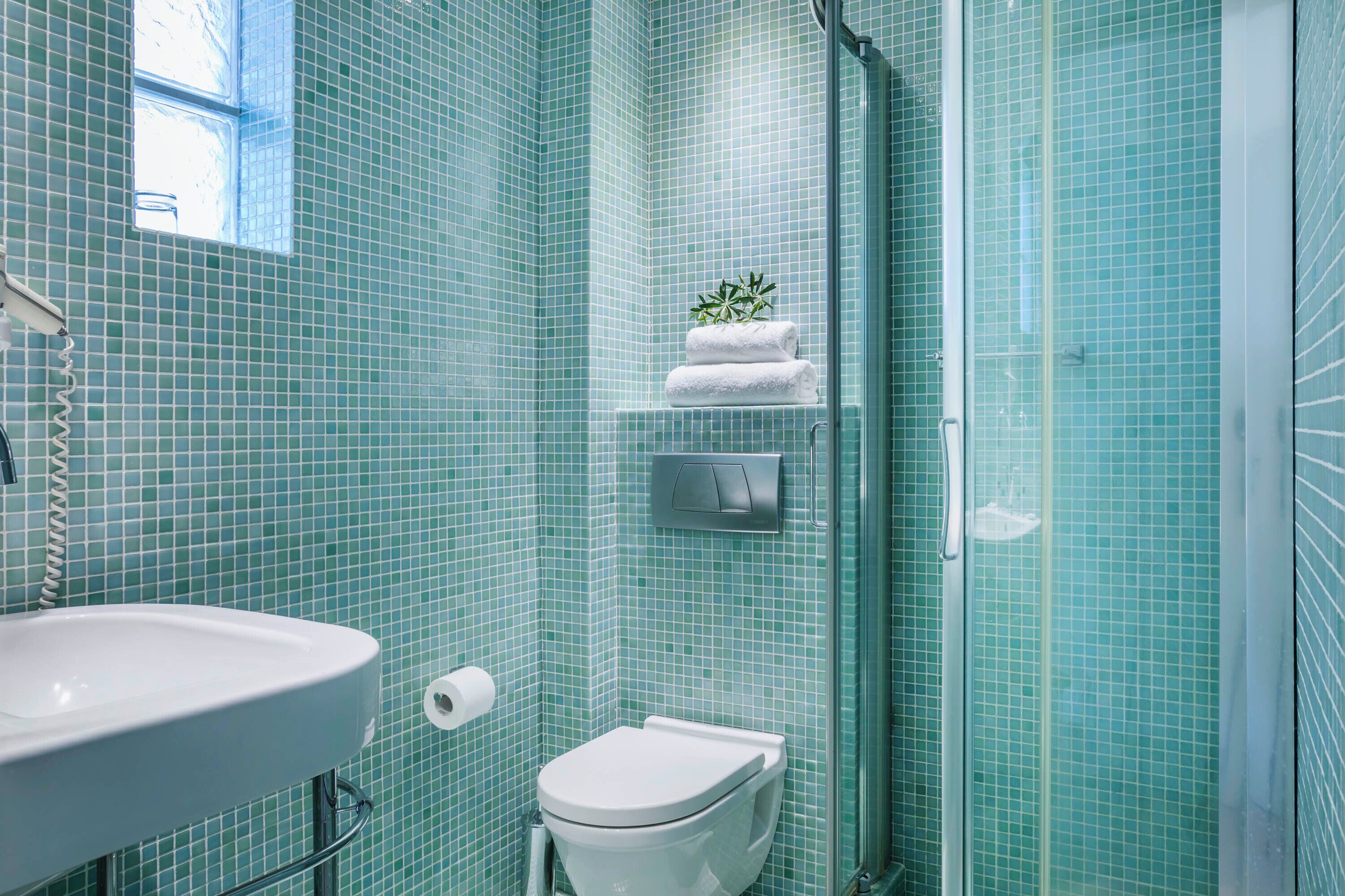 A bathroom with a sink, toilet, and a glass shower enclosure.