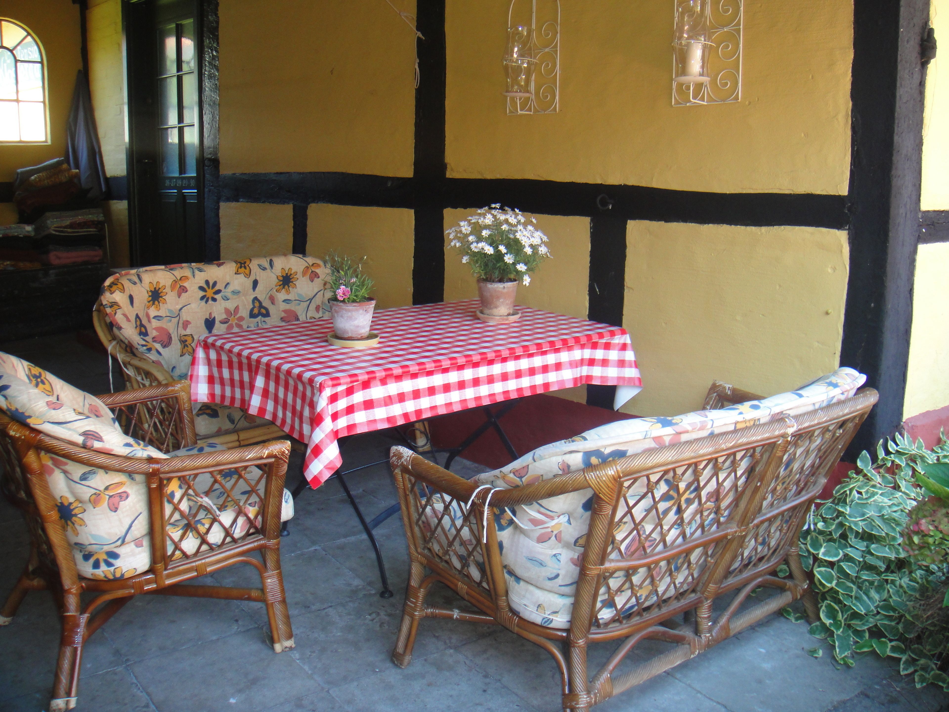 A dining area with wicker furniture and a checkered tablecloth.