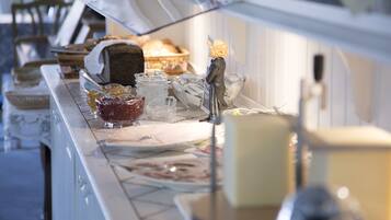 A buffet setup with various food items and utensils.