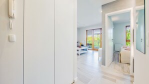 A modern interior with a hallway leading to a living area and a bedroom. - Apartments Sopot (Sopot)