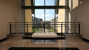 A modern interior with a bench, two planters, and a view through large windows. - Apartments Sopot (Sopot)
