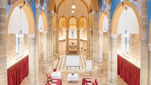 Un amplio salón con techos altos, columnas arqueadas y un altar central.