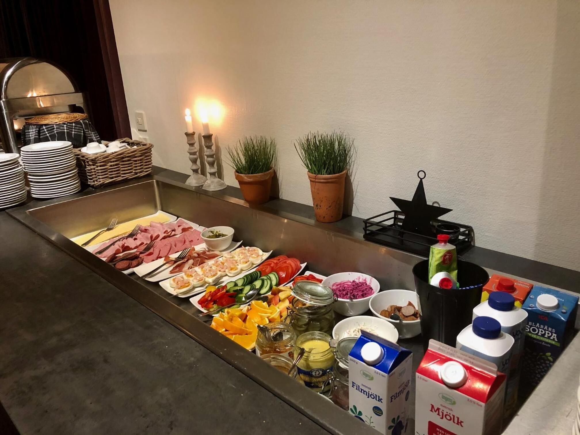 Un buffet proposant une variété de plats, notamment des viandes, des fruits de mer et des légumes, ainsi que des condiments et des boissons.