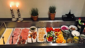 A buffet with various food items including meats, cheeses, fruits, and vegetables. - Lages Motel & Restaurang (Bramhult)