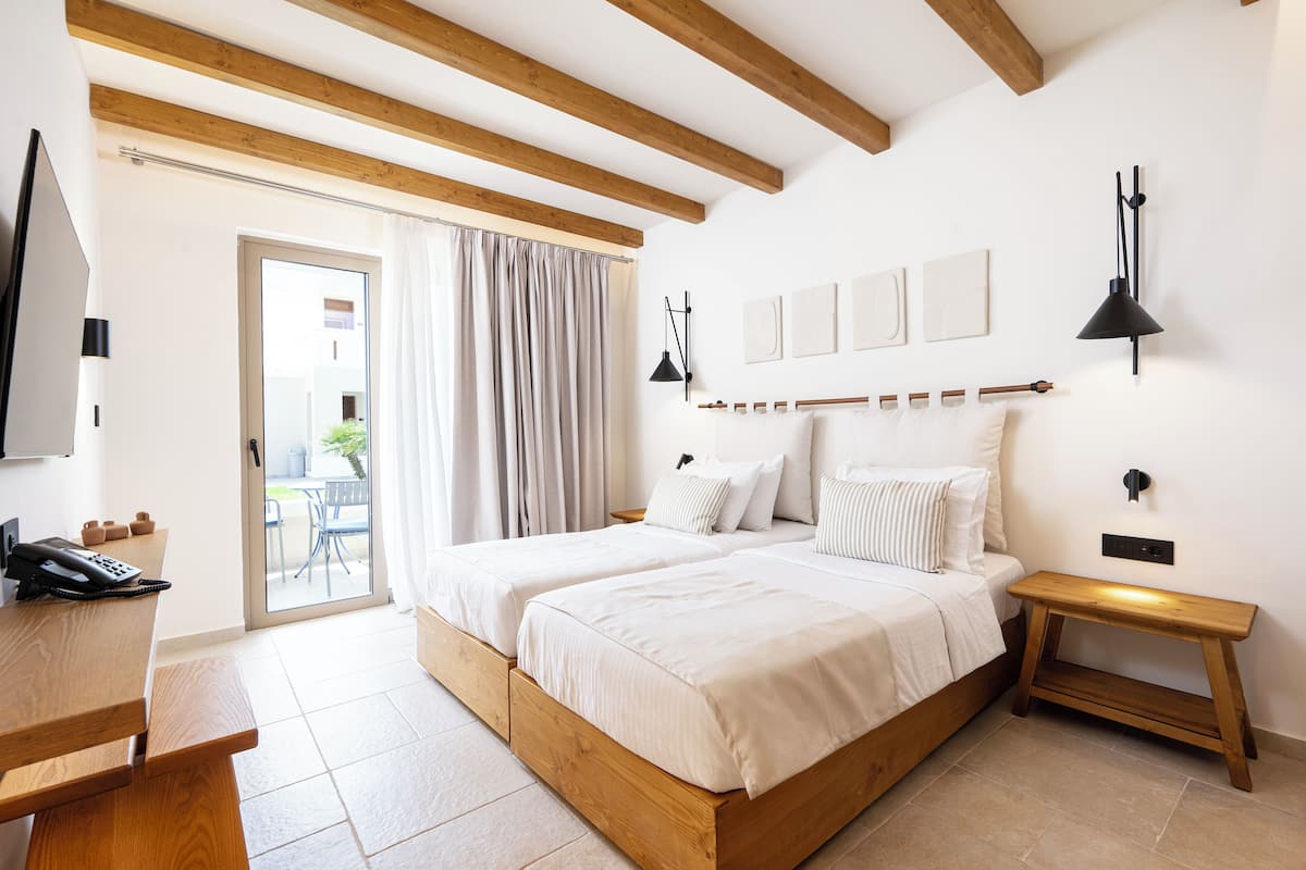 Quarto com cama de madeira, uma mesa e uma cadeira.