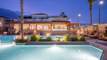 Alberca al aire libre, sombrillas en la alberca y camastros