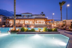 Una piscina al aire libre, sombrillas, tumbonas