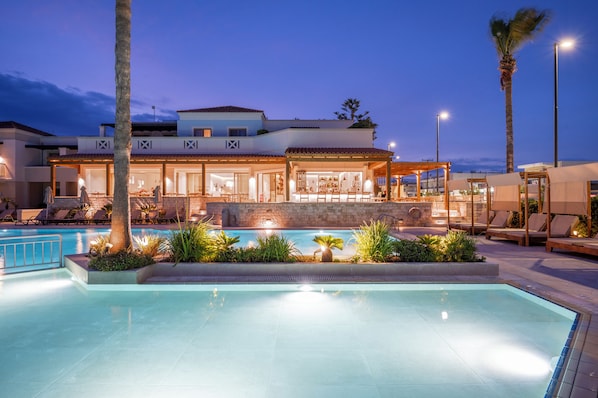 Alberca al aire libre, sombrillas en la alberca y camastros