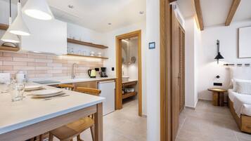 Una cocina moderna con una isla central, sillas de madera e iluminación colgante.
