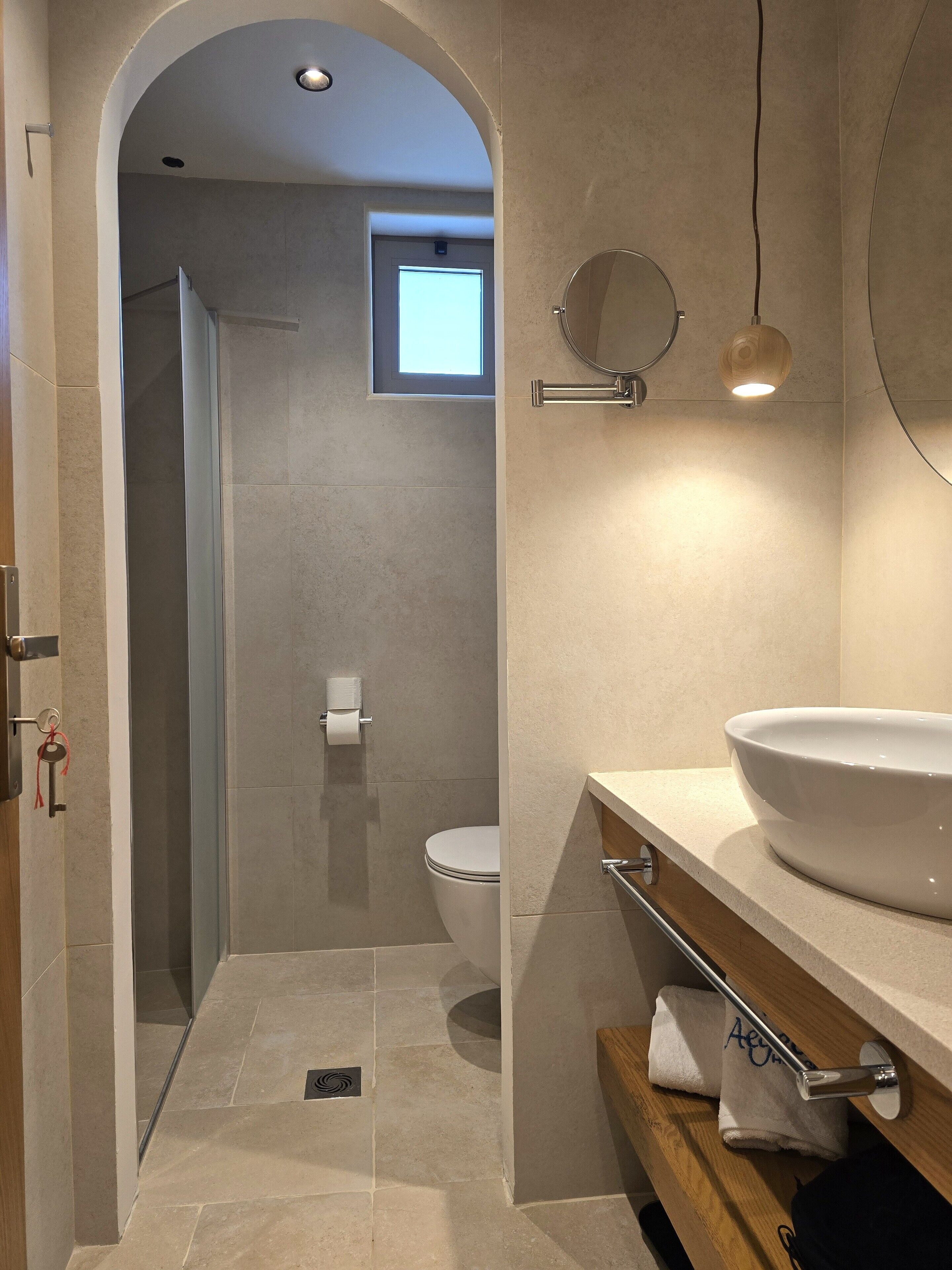 Un baño moderno con un lavamanos grande, un espejo y una zona de ducha.