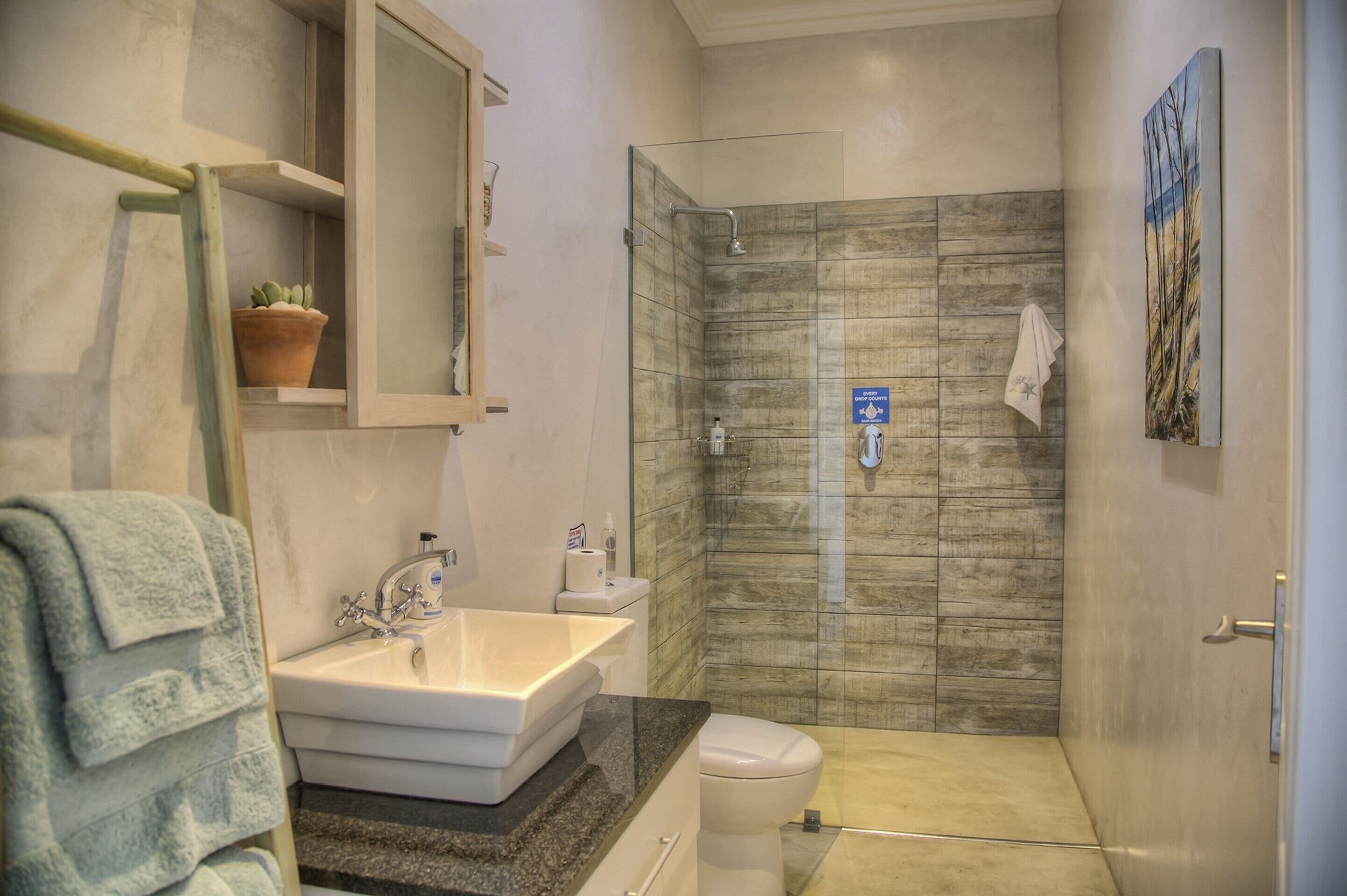 Un baño con lavamanos, inodoro y ducha.