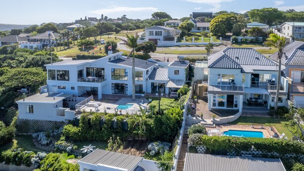 A large, modern two-story house with a pool, surrounded by lush greenery and other residential properties. - The Lookout Guest House (Port Alfred)
