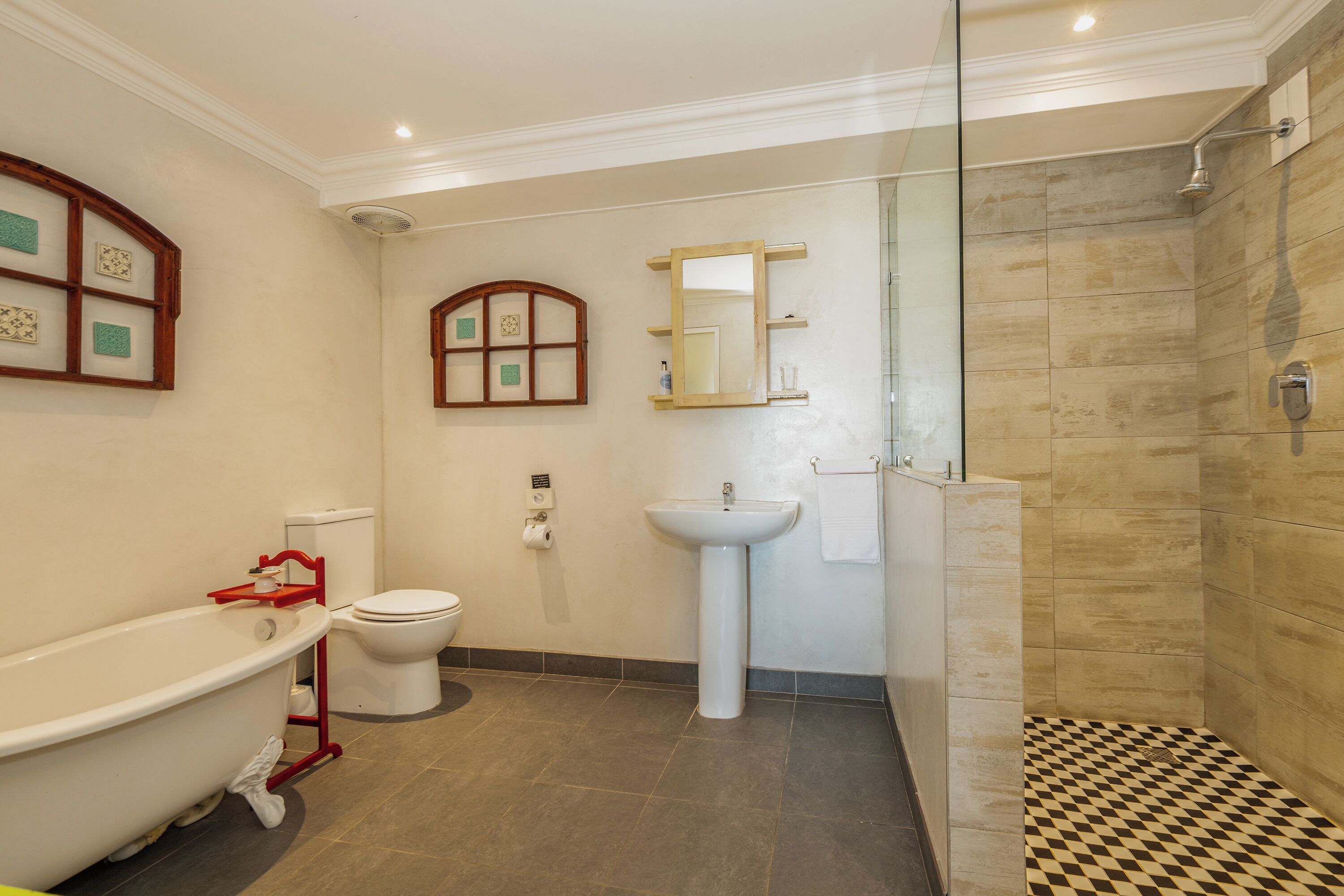 A bathroom with a freestanding bathtub, a toilet, a sink, and a shower area.