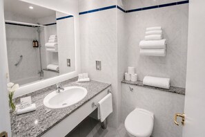 A modern bathroom with a sink, mirror, toilet, and shower. - Lakeside Manor Hotel (Virginia)