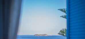A view of a small island in the distance with a clear blue sky.