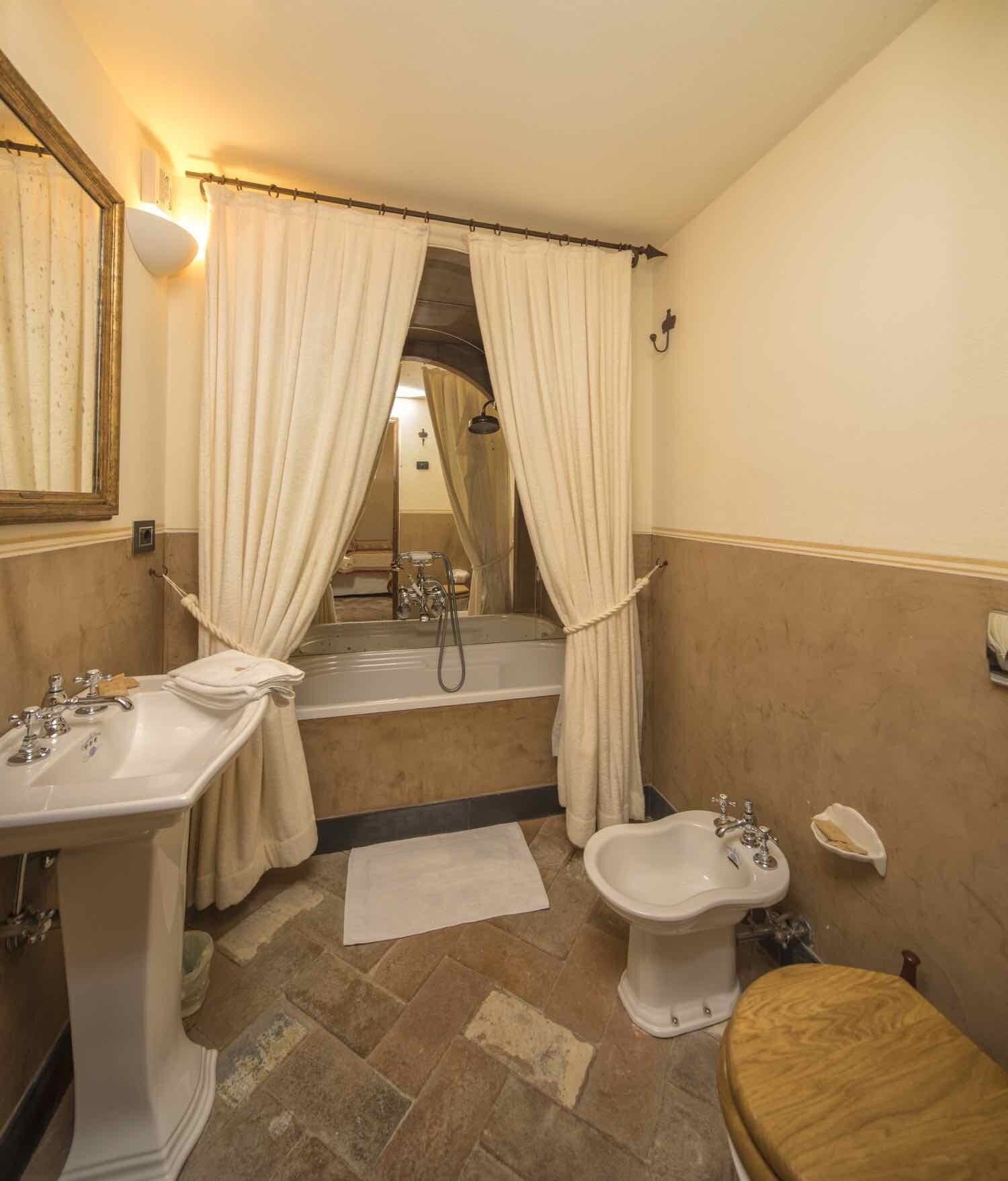 Un baño con bañera, dos lavamanos, un bidé y un inodoro.