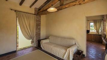 A cozy room with a sofa, a rug, and a wooden ceiling.