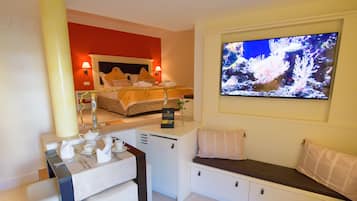 A hotel room with a bed, a TV, a desk with a tea set, and a seating area.