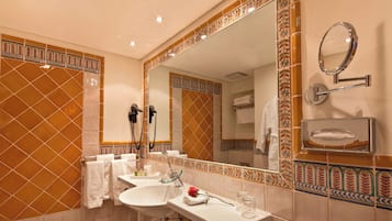 Un baño con un espejo grande, dos lavamanos y un perchero para toallas.