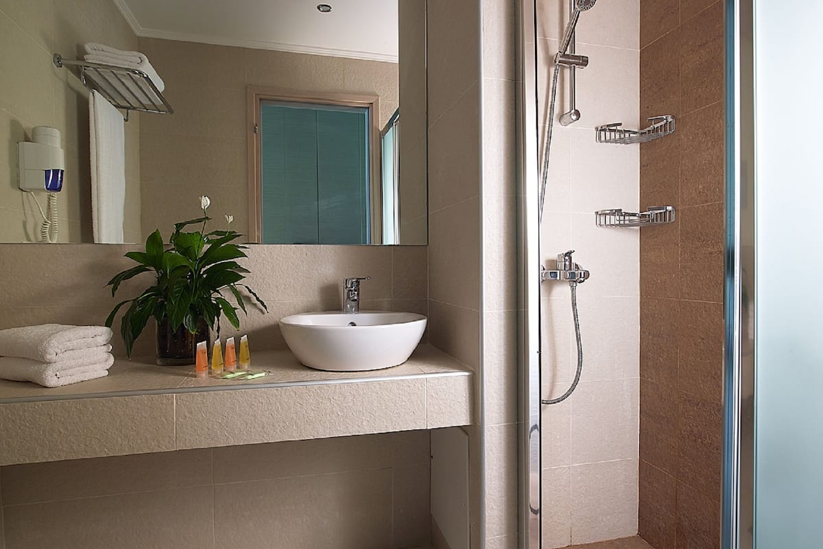 superior room, garden view | bathroom | shower, hair dryer, towels, soap