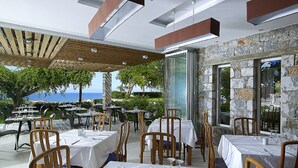 An outdoor dining area with tables and chairs, overlooking the sea. - Eleftheria Hotel (Chania)
