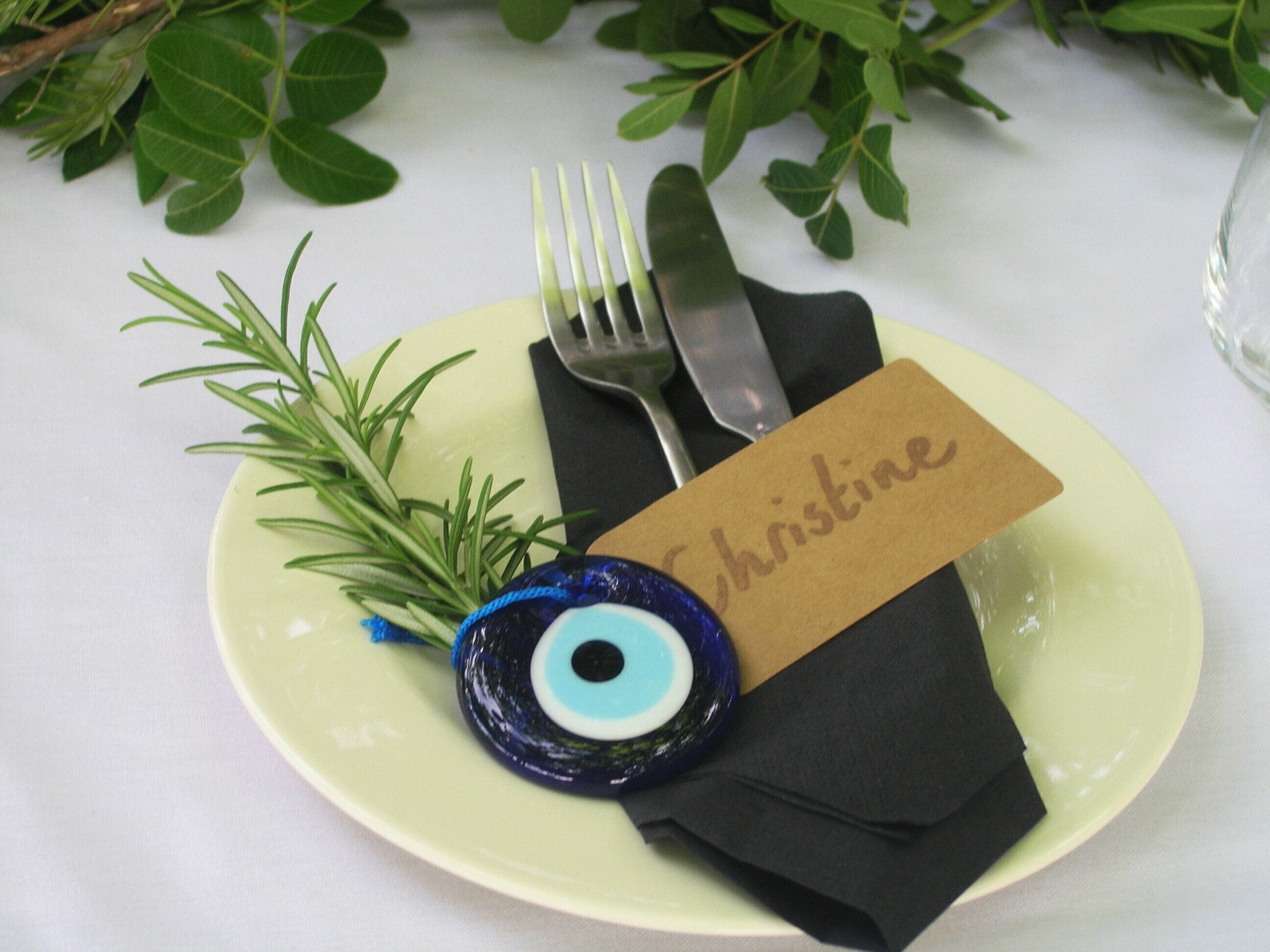 A plate with a name tag, a fork, a knife, and a decorative item.