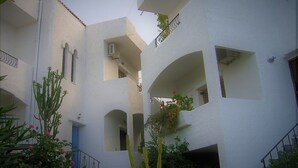 A multi-level building with white walls and balconies. - Emerald (Apokoronas)