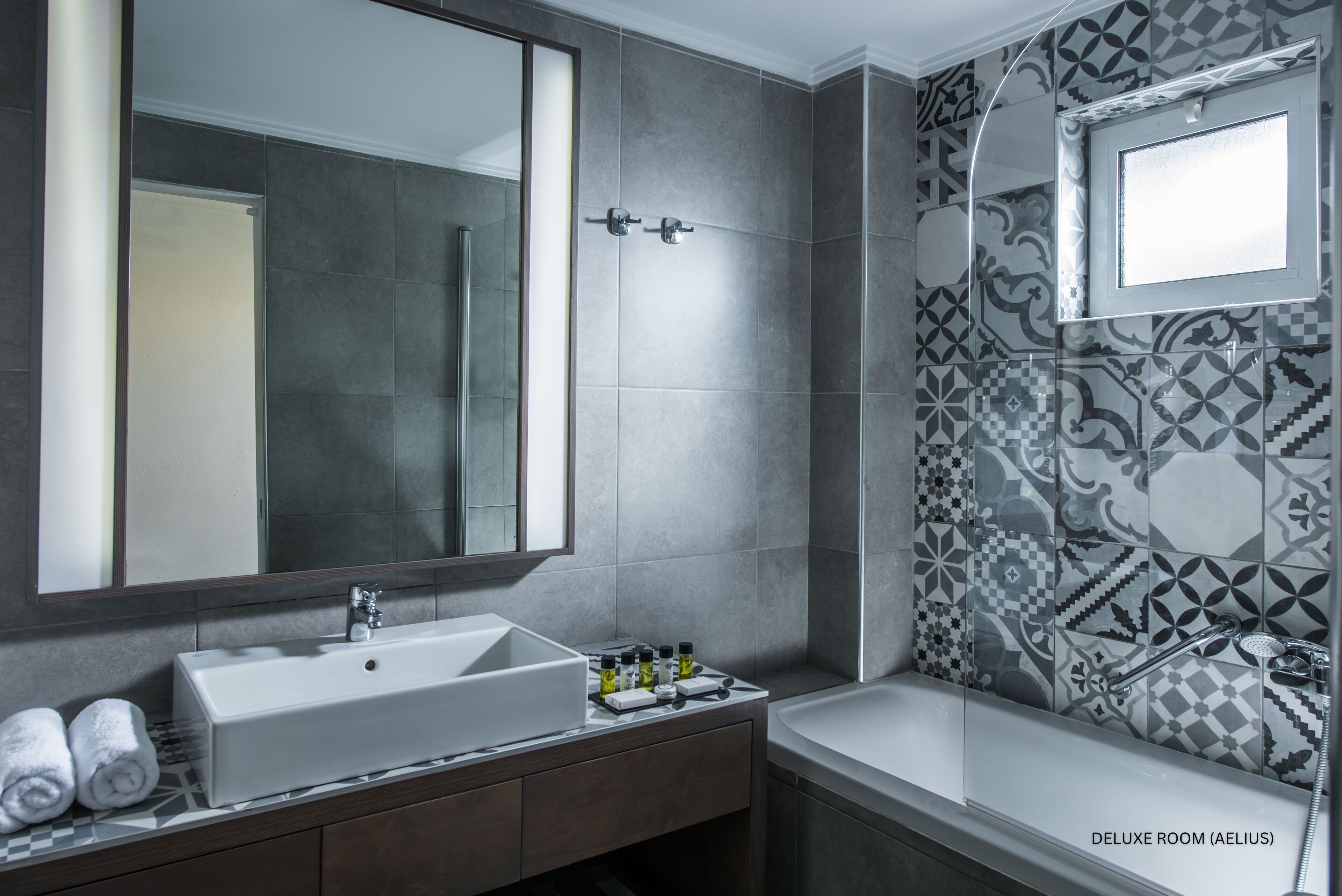 Une salle de bain moderne avec un grand miroir, un lavabo blanc et une baignoire.