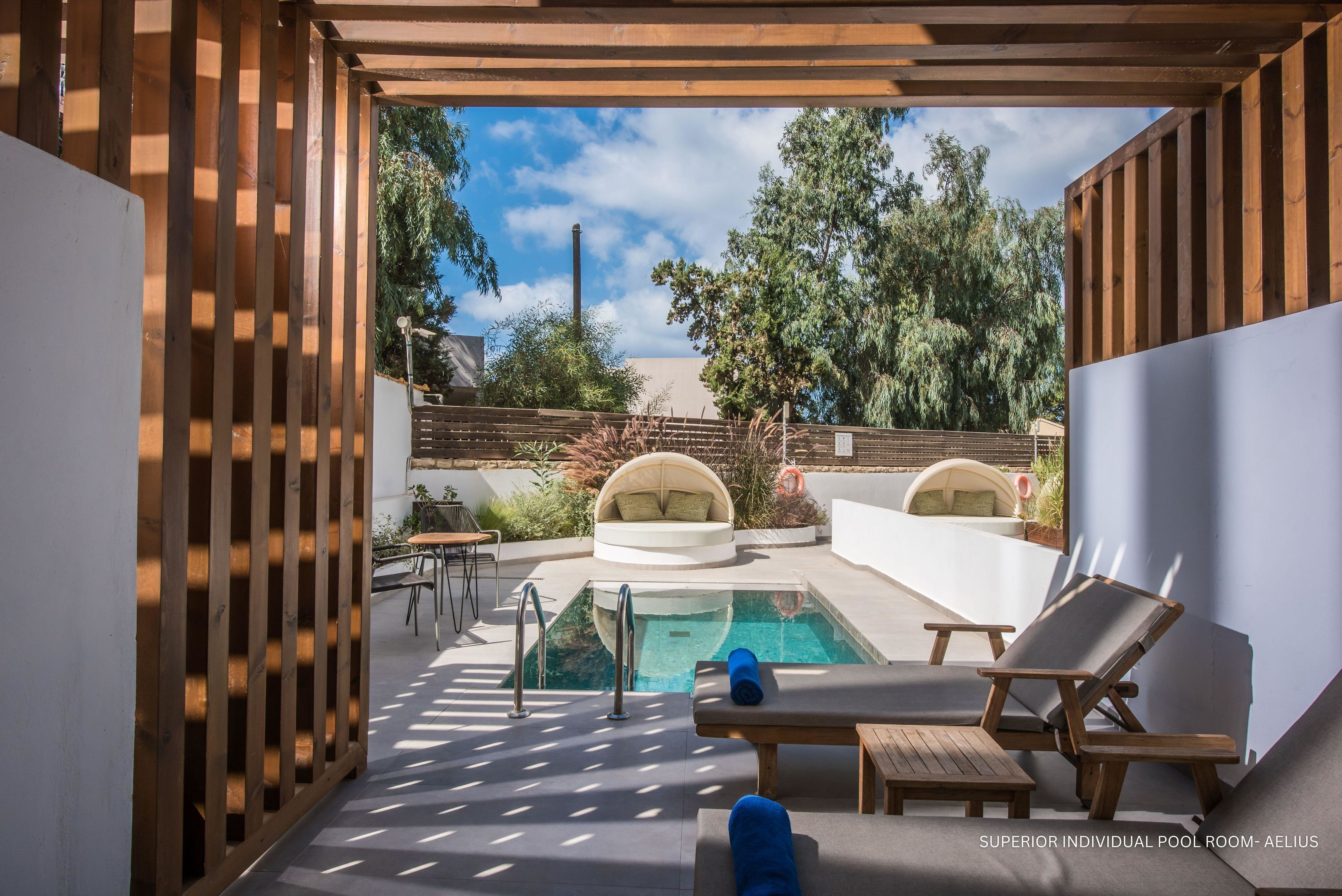 A private pool area with a clear view of the sky, a pool, lounge chairs, and a seating area.