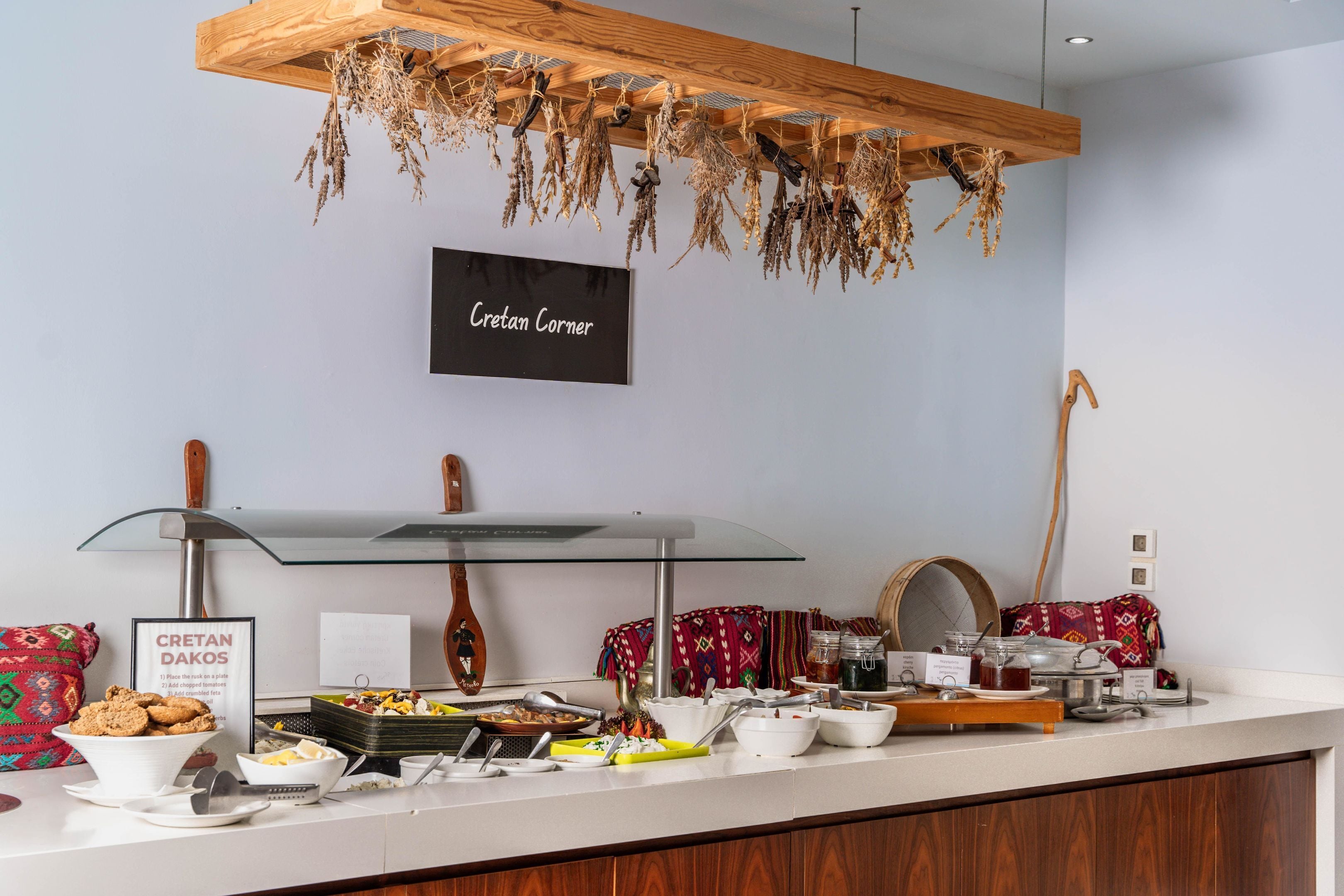 A breakfast buffet with various food items and a sign reading "Cretan Dakos".