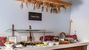 Een ontbijtbuffet met diverse gerechten en een bordje met de tekst 'Cretan Dakos'.
