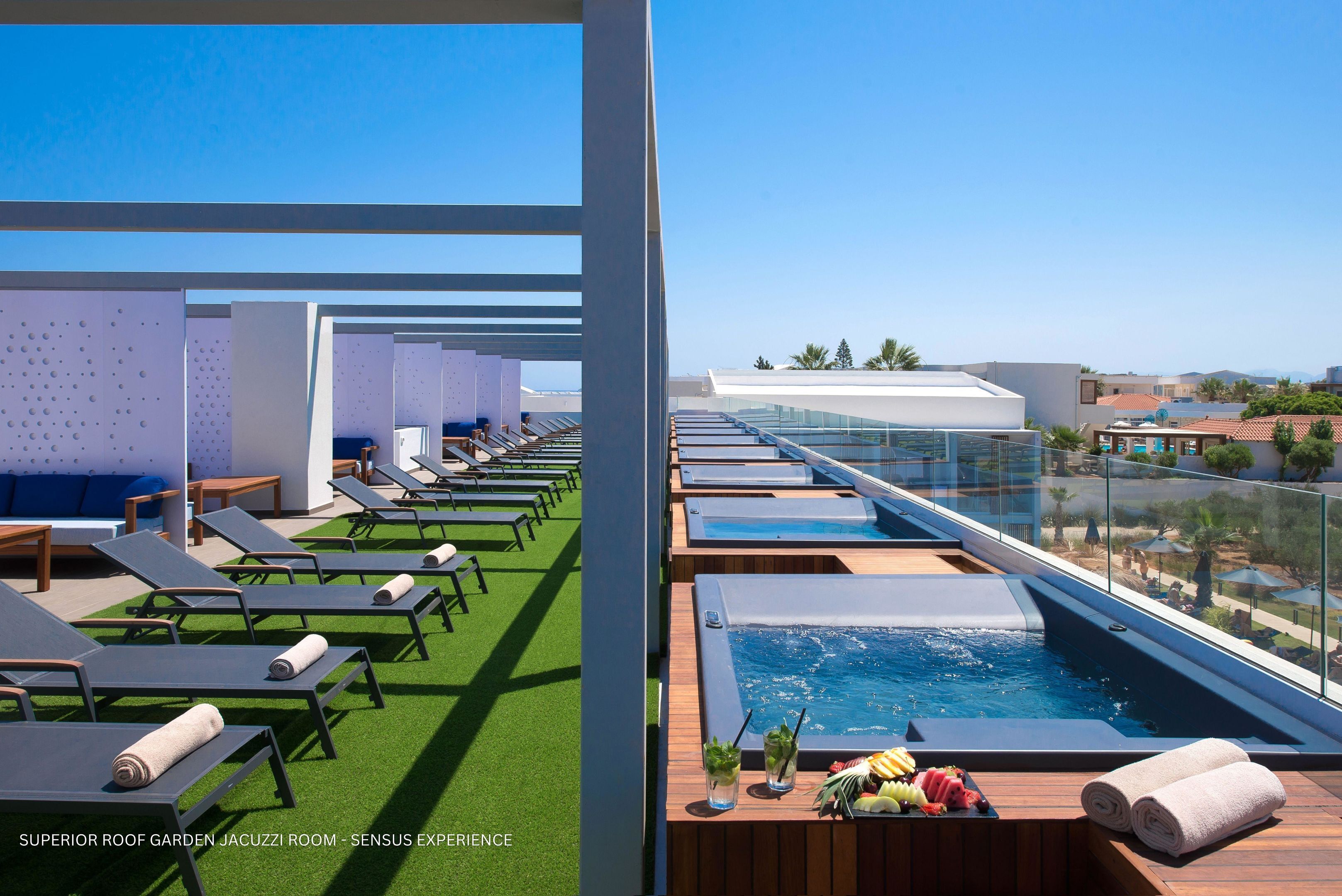 Un jardin sur le toit, équipé de chaises longues, d’un jacuzzi et d’un espace aménagé au bord de la piscine.