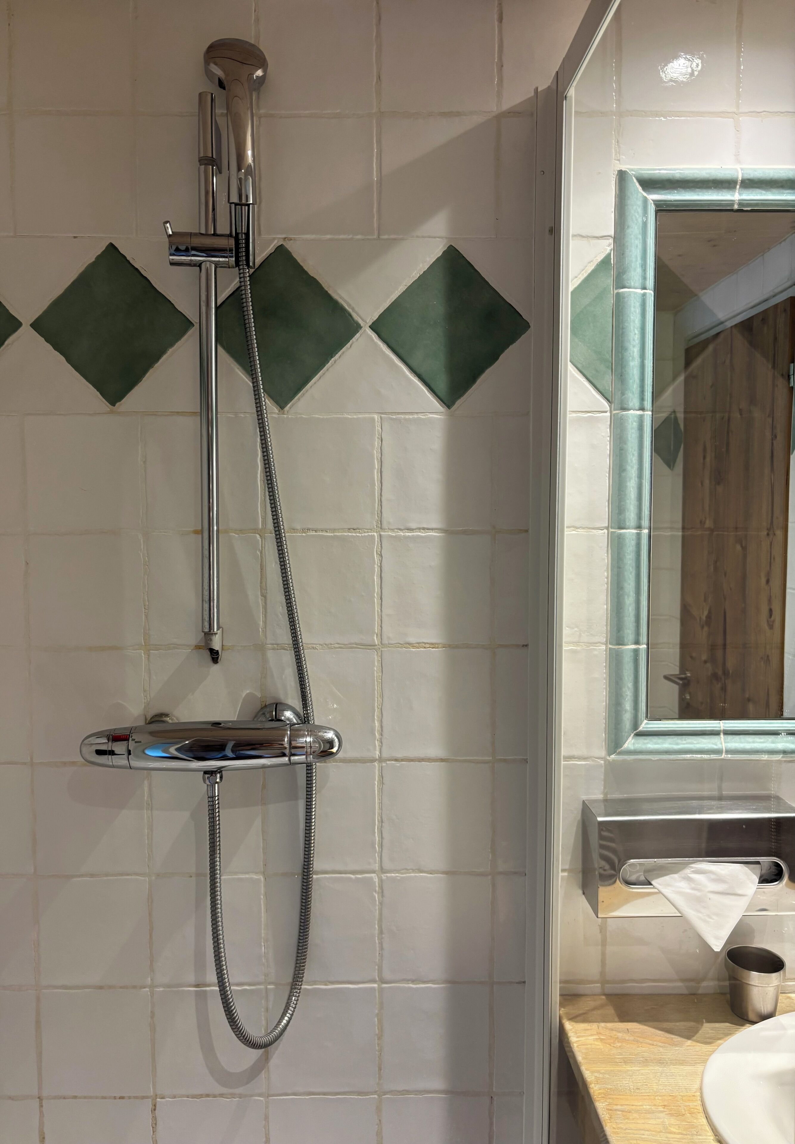 A bathroom with a shower, a sink, and a mirror.
