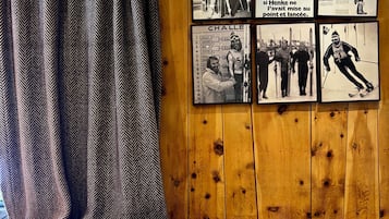 L’intérieur d’un restaurant avec des murs en bois, un rideau à motifs noir et blanc et des photographies encadrées accrochées au mur.