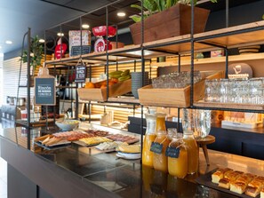Un mostrador de buffet amb diversos aliments, vidrieria i begudes.