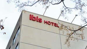 Un edificio con el letrero 'ibis HOTEL', que indica un establecimiento hotelero.