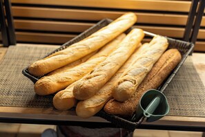 Ein Korb mit Baguettes auf einem Tisch mit einer gewebten Unterlage.