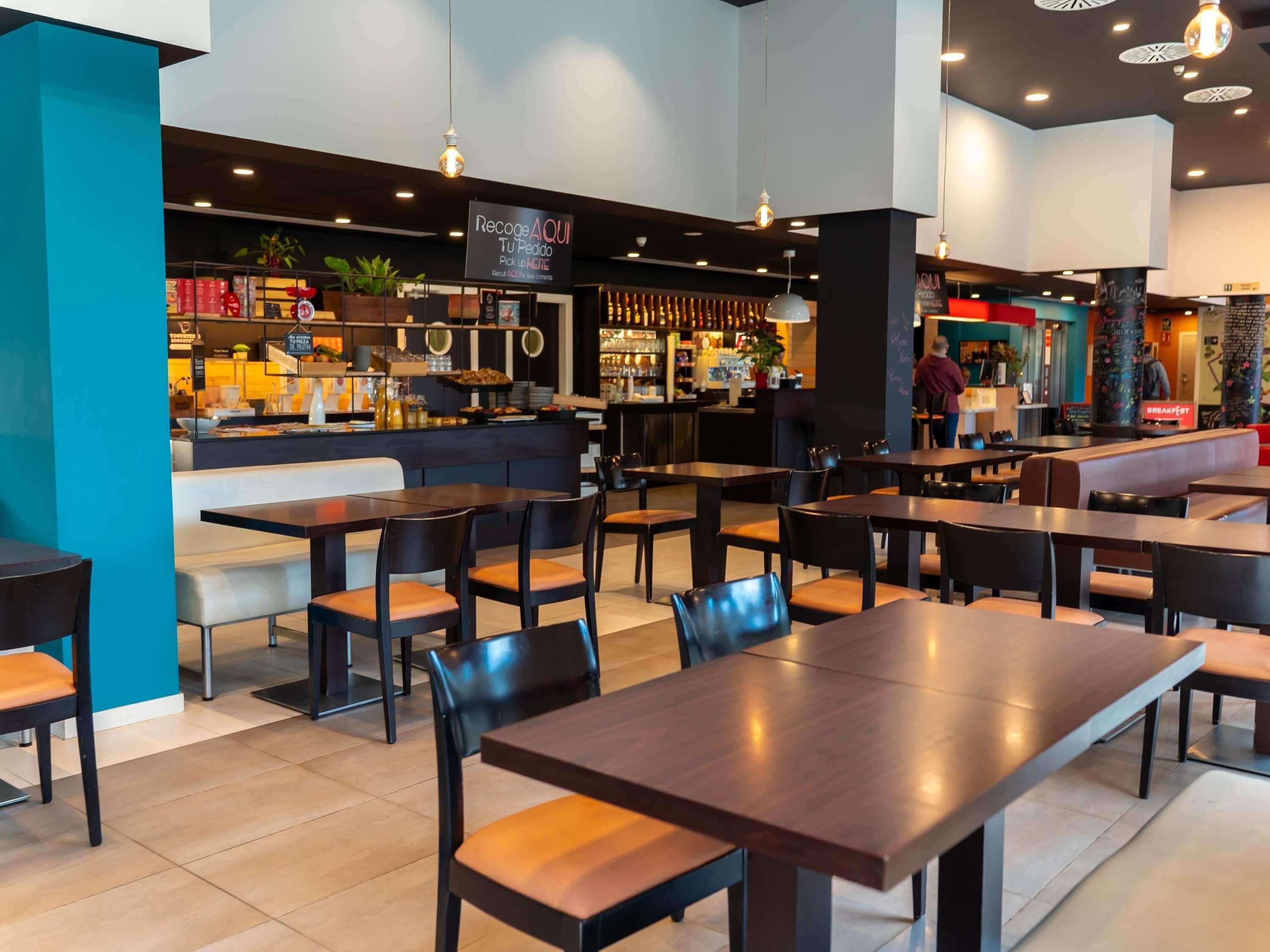 A restaurant with multiple tables and booths, a bar area, and a seating section.