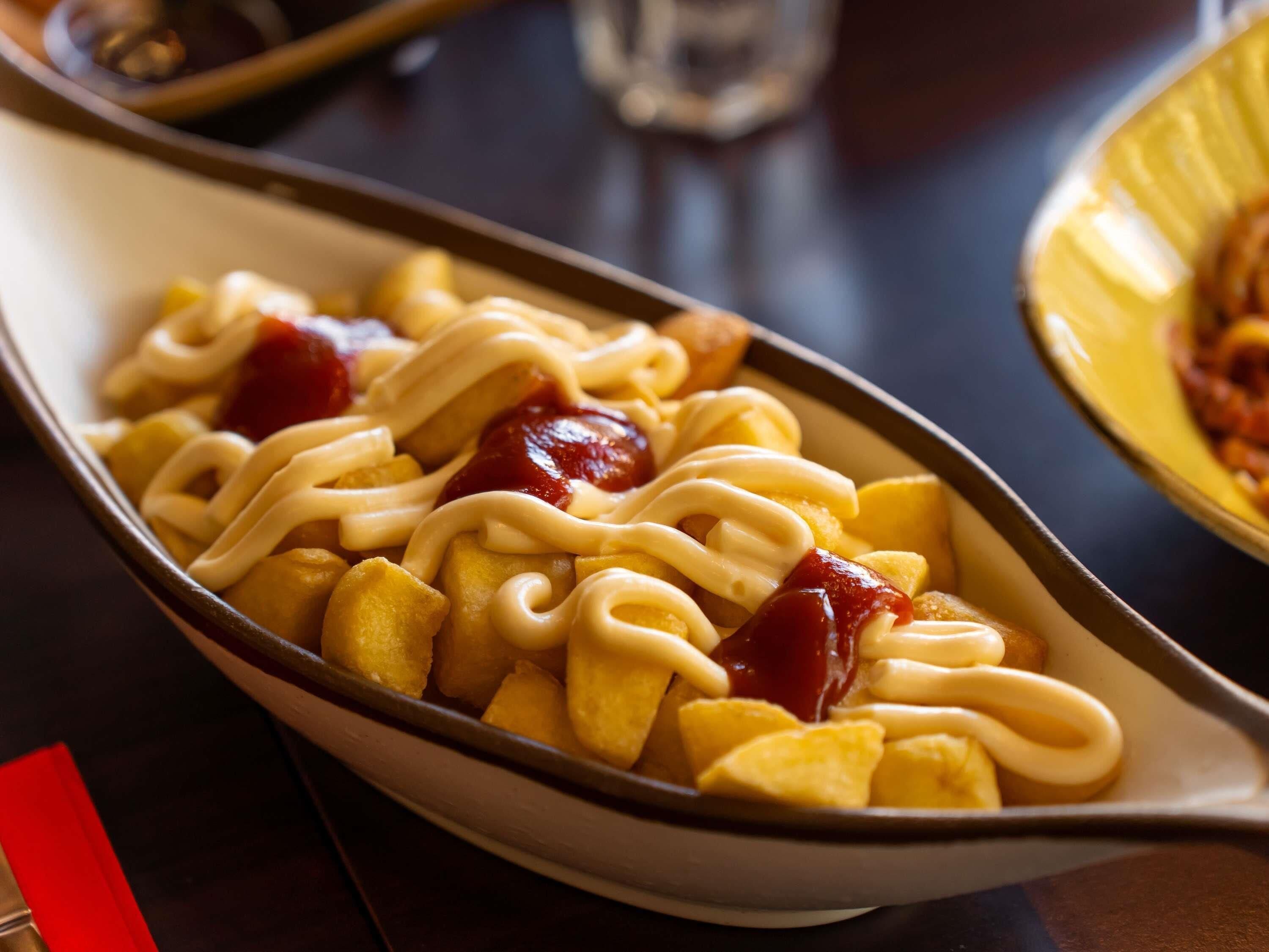 Ein Gericht mit Pommes und Soße in einer Schüssel.