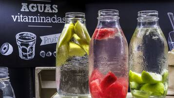Tres botellas de vidrio con líquidos de colores diferentes y rodajas de lima.