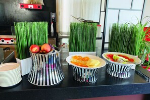 Montaje de bufé con diversos alimentos y elementos decorativos.