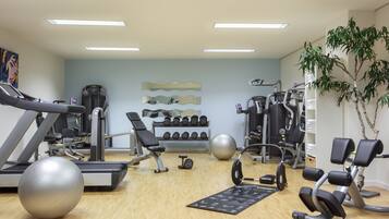 Ein Fitnessstudio mit Laufbändern, Kraftgeräten und Übungsbällen.